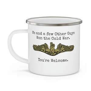May include: White enamel mug with a silver rim and handle. The mug features the text "Me and a few Other Guys Won the Cold War. You're Welcome." and a gold emblem.