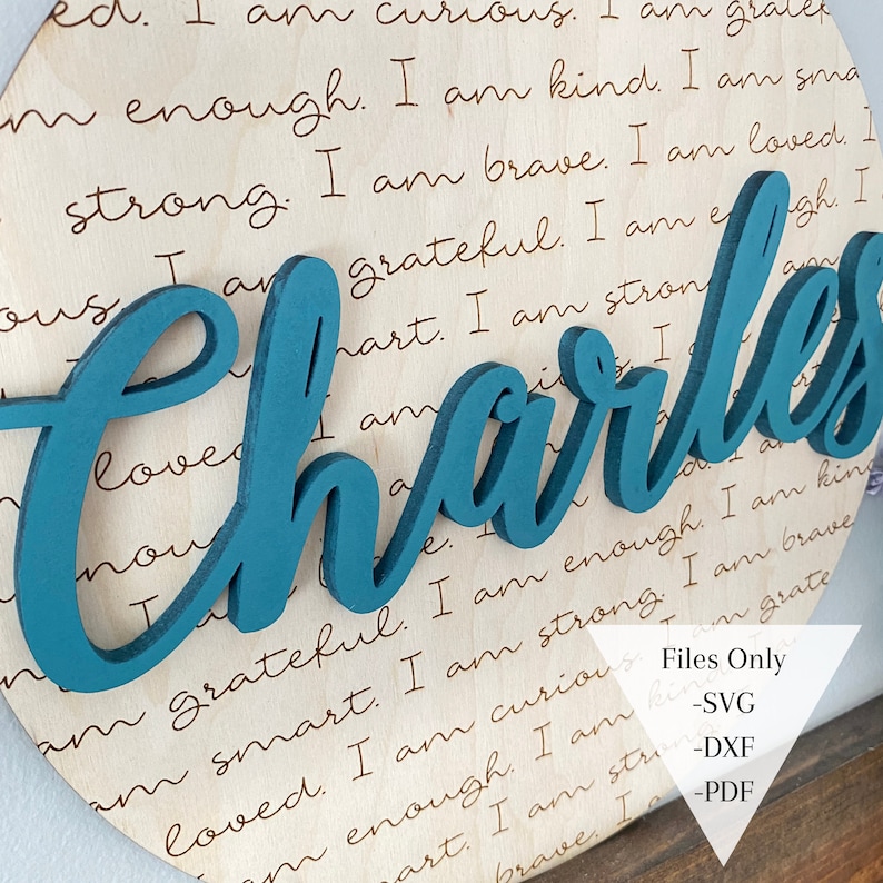 May include: A teal blue wooden name sign with the name "Charles" in a cursive font. The sign is on a wooden background with a handwritten inscription that reads "I am curious. I am grateful. I am smart. I am enough. I am kind. I am strong. I am brave. I am loved. I am..."