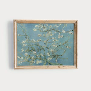 May include: A framed painting of a blooming almond tree with white blossoms against a blue sky. The painting is in a light wood frame.