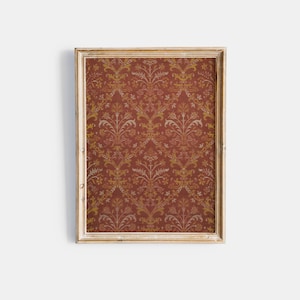 Könnte beinhalten: Ein gerahmter Druck eines Vintage-Tapetenmusters mit rotem Hintergrund und einem goldenen und weißen floralen Muster.