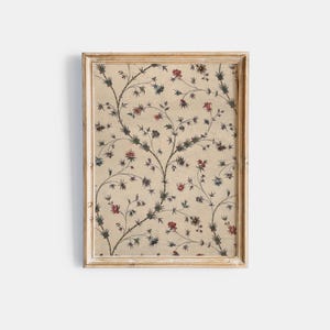 May include: Framed floral print featuring a cream-colored background with a repeating pattern of stylized branches and flowers in red, blue, and green. The frame is a light, distressed gold color, adding a vintage aesthetic.
