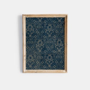 May include: A framed print featuring a blue background with a white floral pattern. The frame is a light wood colour.