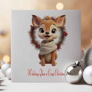 May include: A Christmas card featuring a cartoon deer wearing a white scarf and a red and green wreath around its neck. The card has the text "Wishing You a Cozy Christmas" printed on it.