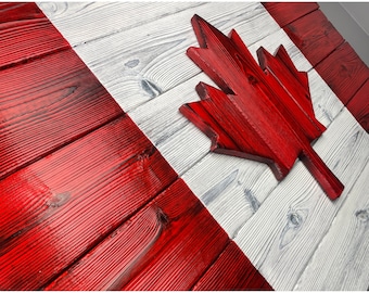 May include: A wooden Canadian flag with a red maple leaf on a white background. The flag is made of reclaimed wood and has a rustic look.