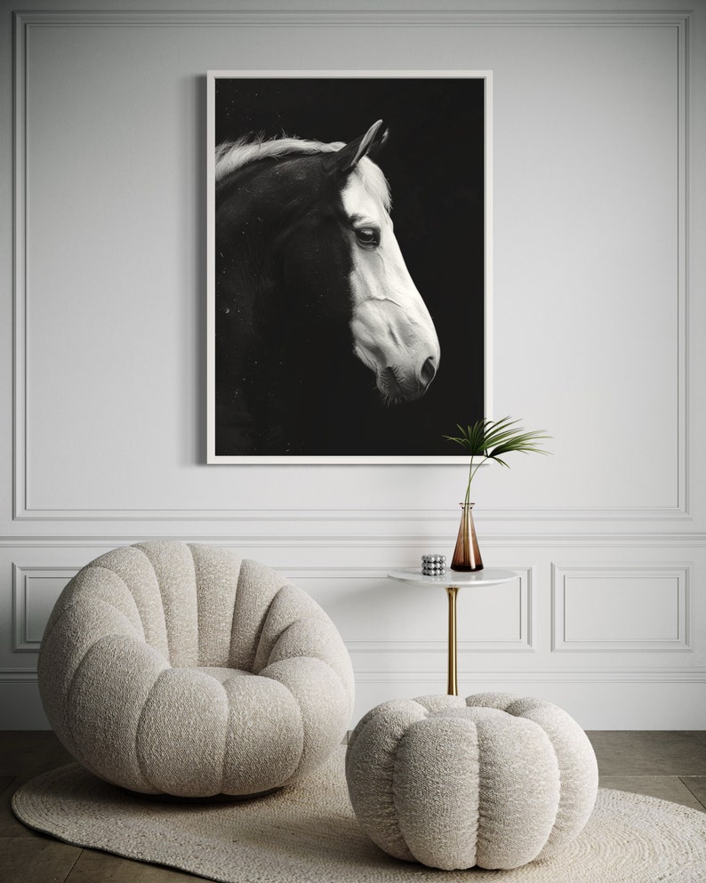 Puede incluir: Una fotograf&iacute;a en blanco y negro de la cabeza de un caballo de perfil, enmarcada y colgada en una pared blanca. El caballo est&aacute; mirando hacia la izquierda, con la cabeza ligeramente inclinada hacia abajo. El fondo es negro y la crin y la cola del caballo ondean con el viento.