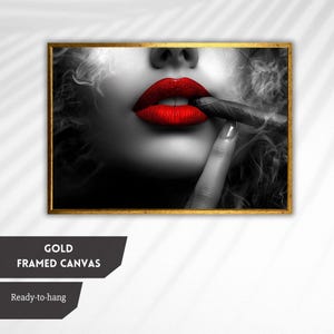 May include: A black and white close-up of a person's lips with bright red lipstick. The person is holding a lit cigar in their mouth and there is smoke coming from the cigar.