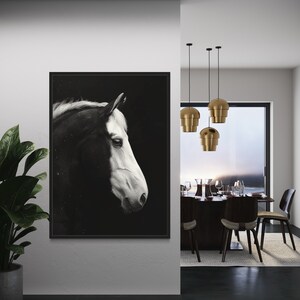 Puede incluir: Fotograf&iacute;a en blanco y negro de la cabeza de un caballo de perfil, enmarcada y colgada en una pared blanca. La pared forma parte de un dise&ntilde;o interior moderno con un comedor visible en el fondo.