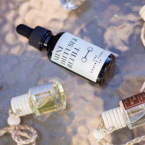 May include: A collection of mini diffuser refill bottles with black caps and white labels. One bottle is labeled "Mini Diffuser Refill" with a horse bit graphic. Other bottles have white tops and decorative cords.
