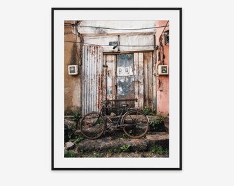 Vertical fine art travel photograph of an old bike leaning against stairs in shabby urban environment in Galle in Sri Lanka with door.