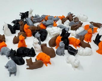 May include: A collection of small, 3D printed cat figurines in various colors, including black, white, gray, orange, and brown. The figurines are all in different poses, some sitting, some standing, and some lying down.