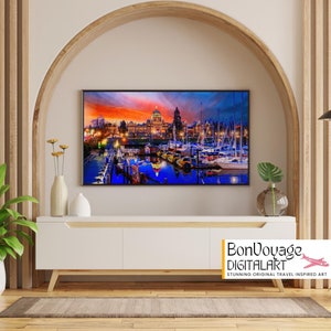 Könnte beinhalten: Ein digitales Gemälde einer Stadtlandschaft bei Sonnenuntergang mit Booten im Hafen. Die Skyline der Stadt ist mit Lichtern beleuchtet und der Himmel ist in leuchtenden Orange- und Lilatönen gehalten. Das Wasser spiegelt die Farben des Himmels und die Lichter der Stadt wider. Das Gemälde ist gerahmt und hängt an einer Wand über einem weißen Schrank.