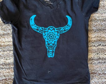 May include: Black t-shirt with a blue bull skull design. The skull has a mandala pattern inside. The shirt has a V-neck and the brand "Faded Glory" is printed on the tag.