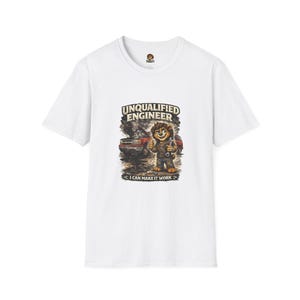 May include: White t-shirt featuring a cartoon bear holding tools, with the text "UNQUALIFIED ENGINEER" above and "I CAN MAKE IT WORK" below. The bear stands in front of a car with smoke. A fun, humorous design.