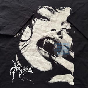 May include: Black t-shirt featuring a detailed, grayscale illustration of a vampire with fangs bared. The word "Abyssal" is printed in a stylized font at the bottom. The design is a bold, graphic statement.