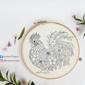 May include: Black and white line art embroidery hoop featuring a rooster with a floral design. The rooster is surrounded by flowers and leaves.