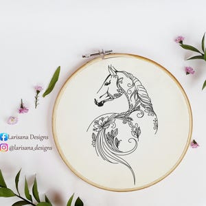 May include: An embroidery hoop featuring a black line drawing of a horse's head and neck, adorned with floral and leaf patterns. The design is on a cream-colored fabric, set within a wooden hoop. The text "Larisana Designs" and social media handles are visible.