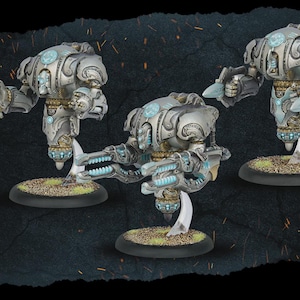 May include: Three silver and blue miniature robot figures with intricate mechanical details. Each figure is mounted on a circular base with a grassy texture. The robots have articulated arms and glowing blue accents, suggesting a futuristic or science fiction theme.