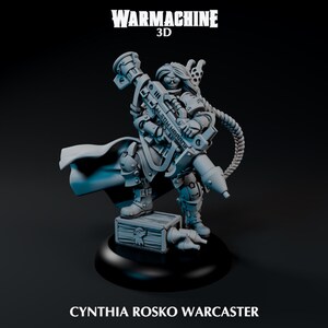 May include: A gray 3D-printed miniature of Cynthia Rosko Warcaster from Warmachine. The figure is holding a large weapon with the text "LETH HARANI" on it. The miniature is standing on a wooden crate and a black base.