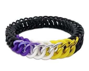 May include: A black, purple, white, silver, and yellow chainmail bracelet. The bracelet is made of interlocking metal rings, with the colors arranged in a pattern. The bracelet is a symbol of non-binary pride.