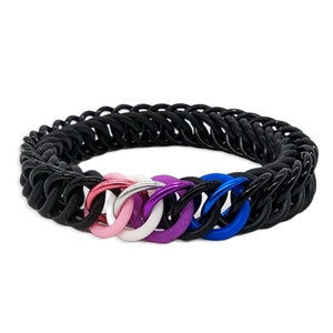 May include: A black chain bracelet with a row of five colorful rings. The rings are pink, white, purple, white, and blue.