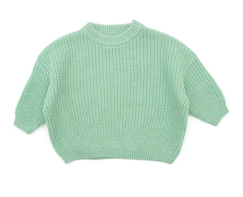 May include: A light green knitted sweater with a crew neck and long sleeves.