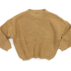 May include: A brown knitted sweater with a round neckline and long sleeves.