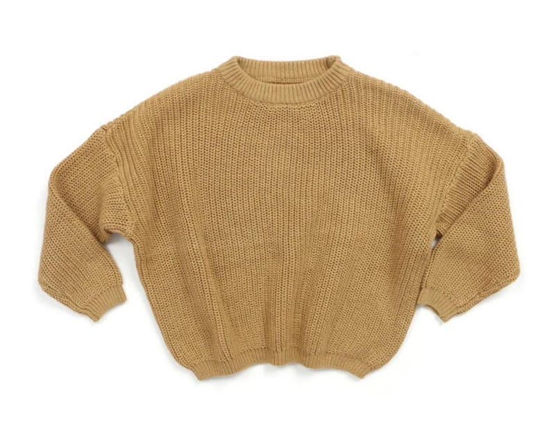 May include: A brown knitted sweater with a round neckline and long sleeves.