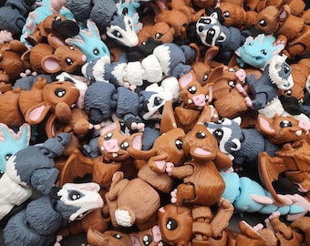 Puede incluir: Una colección de pequeñas figuritas de animales de colores. Las figuritas están hechas de plástico y tienen partes móviles. Están dispuestas en una pila, con algunas de las figuritas mirando hacia la cámara y otras mirando hacia afuera.