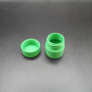 May include: A green plastic container with a textured surface. The container is open and the lid is separate.