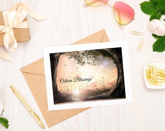 May include: A greeting card with a nature scene of a tree and a sunset. The text "Ostara Blessings" is written in black cursive font.