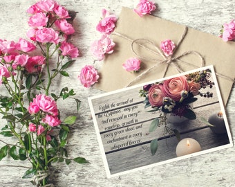 May include: A postcard with a quote about the Equinox, featuring a bouquet of pink and white flowers in a vase, two white candles, and a wooden background.