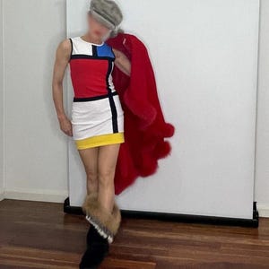 May include: A woman wearing a short, sleeveless dress with a geometric pattern in red, blue, yellow, and white. She is also wearing a red fur coat and black boots.