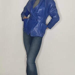 May include: A blue leather blazer with a double-breasted closure and a fitted silhouette.