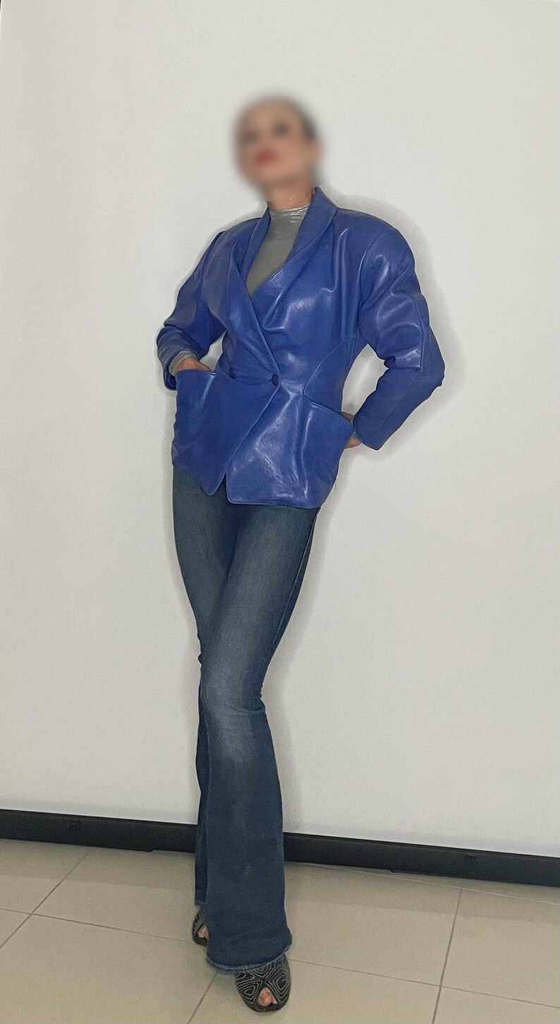 May include: A blue leather blazer with a double-breasted closure and a fitted silhouette.