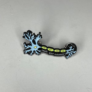 May include: Black and blue enamel pin depicting a neuron with the text "reach your potential".