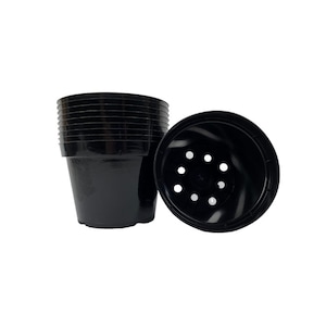 May include: A stack of ten black plastic plant pots with drainage holes. The pots are 4 inches in diameter.
