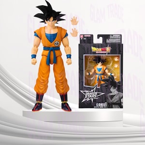 Może przedstawiać: Pomarańczowo-niebieska figurka Goku z serii Dragon Ball Super, na białej platformie. Figurka ma czarne włosy i dwa zestawy wymiennych dłoni. Widoczne opakowanie z logo Dragon Stars i imieniem postaci.