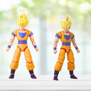Puede incluir: Dos figuras de acci&oacute;n de un personaje con pelo amarillo puntiagudo, vistiendo un atuendo naranja y azul, y un halo sobre la cabeza. Las figuras est&aacute;n de pie. El fondo est&aacute; borroso.