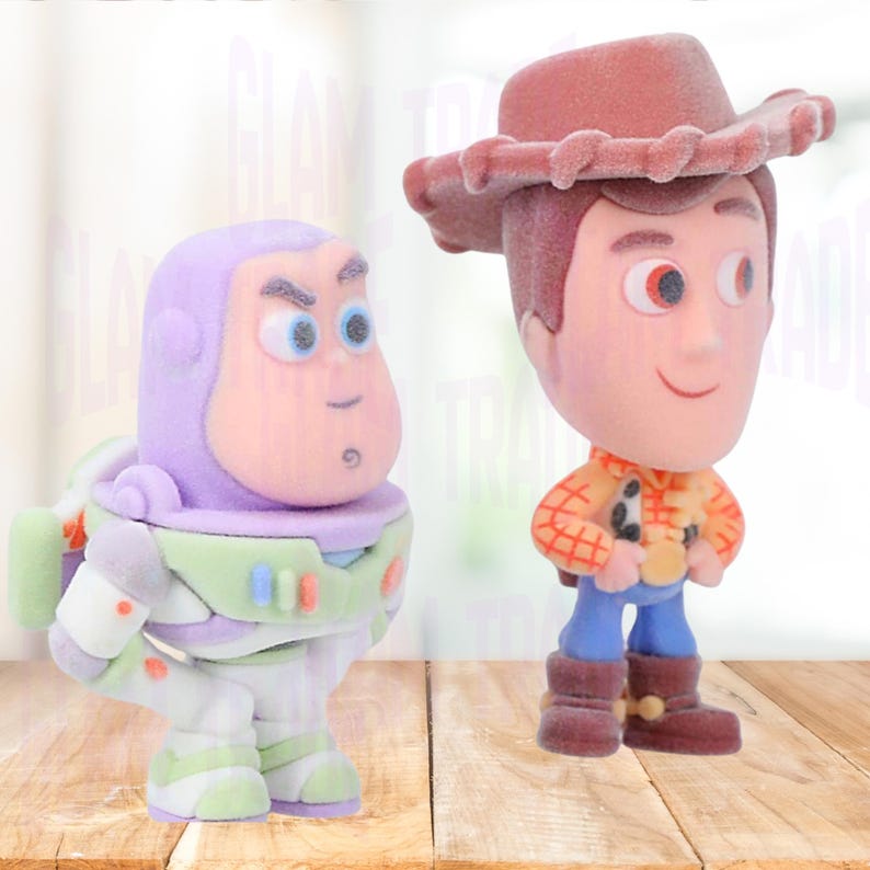 Może przedstawiać: Dwie figurki postaci z filmu animowanego Toy Story. Buzz Lightyear ma na sobie fioletowo-biały kombinezon kosmiczny. Woody, kowboj, nosi brązowy kapelusz, koszulę w kratę, niebieskie spodnie i brązowe buty.