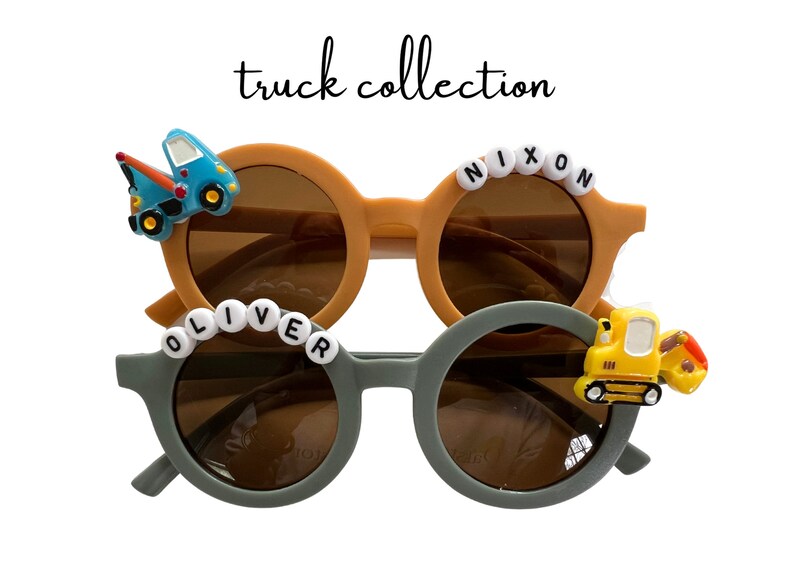 May include: Two pairs of round sunglasses with brown lenses. One pair is tan with a blue tow truck, the other is gray with a yellow excavator. The text "truck collection" is written above the sunglasses.