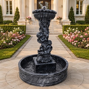 May include: A dark gray stone fountain featuring a circular basin and a central pedestal adorned with sculpted figures of three cherubs. The top tier is a fluted bowl that collects water, which cascades down into the large, round base below.