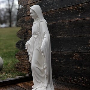 Realistically painted Virgin mary statue with a blue and gold shawl standing on a snake made out of solid concrete making it durable in all weather conditions.