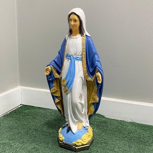 Realistically painted Virgin mary statue with a blue and gold shawl standing on a snake made out of solid concrete making it durable in all weather conditions.