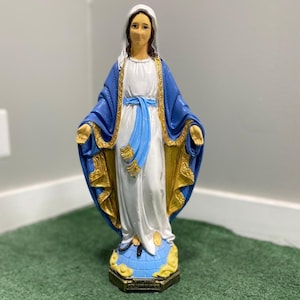 Realistically painted Virgin mary statue with a blue and gold shawl standing on a snake made out of solid concrete making it durable in all weather conditions.