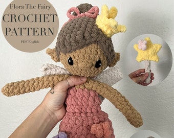 May include: Crochet pattern for a brown-haired fairy doll with a pink dress, white wings, and a yellow star wand. The doll is holding a wand with a yellow star on top. The pattern is available in PDF format and is written in English.