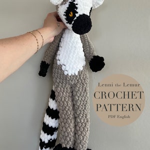 May include: Crochet pattern for a gray and white lemur with a black and white striped tail. The pattern is called "Lenni the Lemur Crochet Pattern" and is available in PDF format in English.