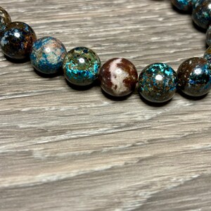 May include: A bracelet made of blue, brown, and white patterned beads.