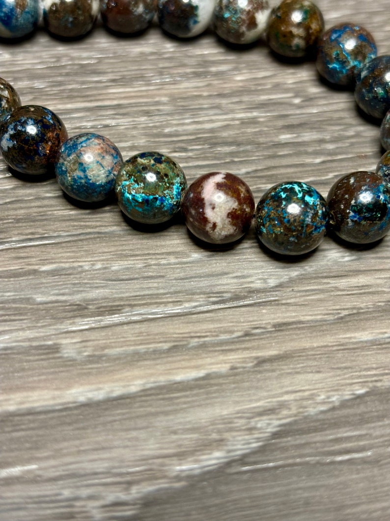 May include: A bracelet made of blue, brown, and white patterned beads.