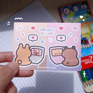 以下が含まれることがあります： 2匹の茶色のクマがラップトップに座っているステッカーシート。ハート、星、そして「Chonky lovers」と「@chonkerclub」の文字が書かれています。