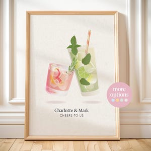 May include: A framed wall art print featuring a pink cocktail and a green cocktail clinking together. The pink drink contains citrus slices, while the green drink includes lime, mint, and a striped straw. Text reads: Charlotte & Mark CHEERS TO US.